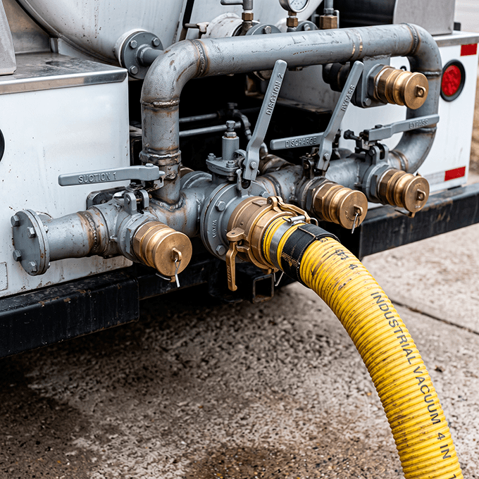 Close-up of industrial high-pressure suction valve manifolds on an emergency vacuum tank truck