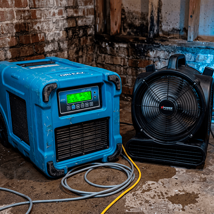 Industrial LGR dehumidifier and high-velocity axial air movers drying wet concrete foundation framing inside a St. Louis basement